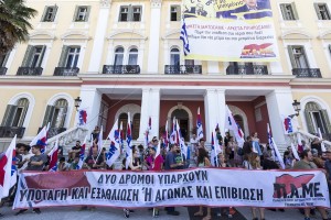 Μέλη του ΠΑΜΕ κρατούν μεγάλο πανό που γράφει "δυο δρόμοι υπάρχουν: υποταγή και εξαθλίωση ή αγώνας και επιβίωση" έξω από την είσοδο του υπουργείου Μακεδονίας- Θράκης όπου έχουν κάνει συμβολική  κατάληψη,  με στόχο να διαμαρτυρηθούν στα νέα μέτρα που συμφώνησε η κυβέρνηση με τους δανειστές, Θεσσαλονίκη, Τετάρτη 15 Ιουλίου 2015. Οι συγκεντρωμένοι έχουν καταλάβει την είσοδο στον αύλειο χώρο του υπουργείου, αλλά και την είσοδο στο κτίριο των υπηρεσιών, στο οποίο έχουν αναρτήσει πανό, που καταλαμβάνει μεγάλο μέρος της πρόσοψής του. Στο πανό αναγράφεται "1o μνημόνιο, 2ο μνημόνιο, 3ο μνημόνιο- Αρκετά ματώσαμε, αρκετά πληρώσαμε- Πάρε την υπόθεση στα χέρια σου λαέ- Μπλόκο στα νέα μέτρα και στα μνημόνια διαρκείας. Όλοι στον δρόμο, ξεσηκωμός, μην πτωχεύσει ο λαός". ΑΠΕ ΜΠΕ/PIXEL/ΣΩΤΗΡΗΣ ΜΠΑΡΜΠΑΡΟΥΣΗΣ